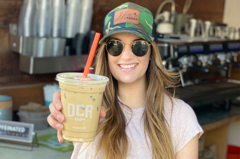Young Woman Holding An Iced Drink At Espresso Stand