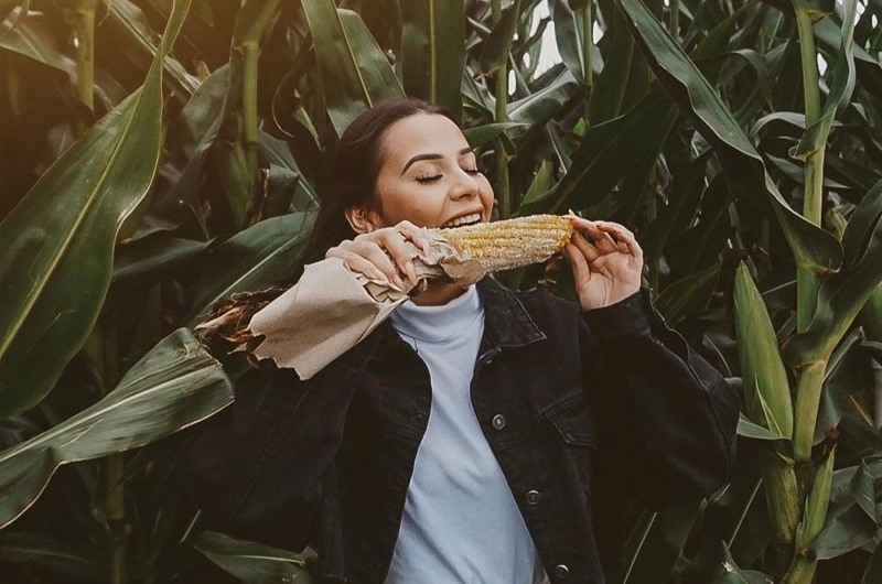 Woman Eating Roasted Corn
